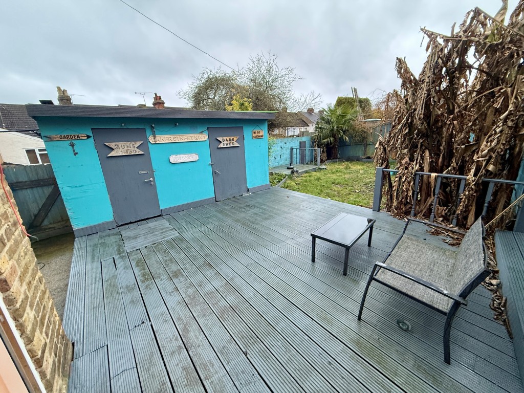 Lot: 153 - VACANT THREE-BEDROOM HOUSE - Decked area with outbuilding